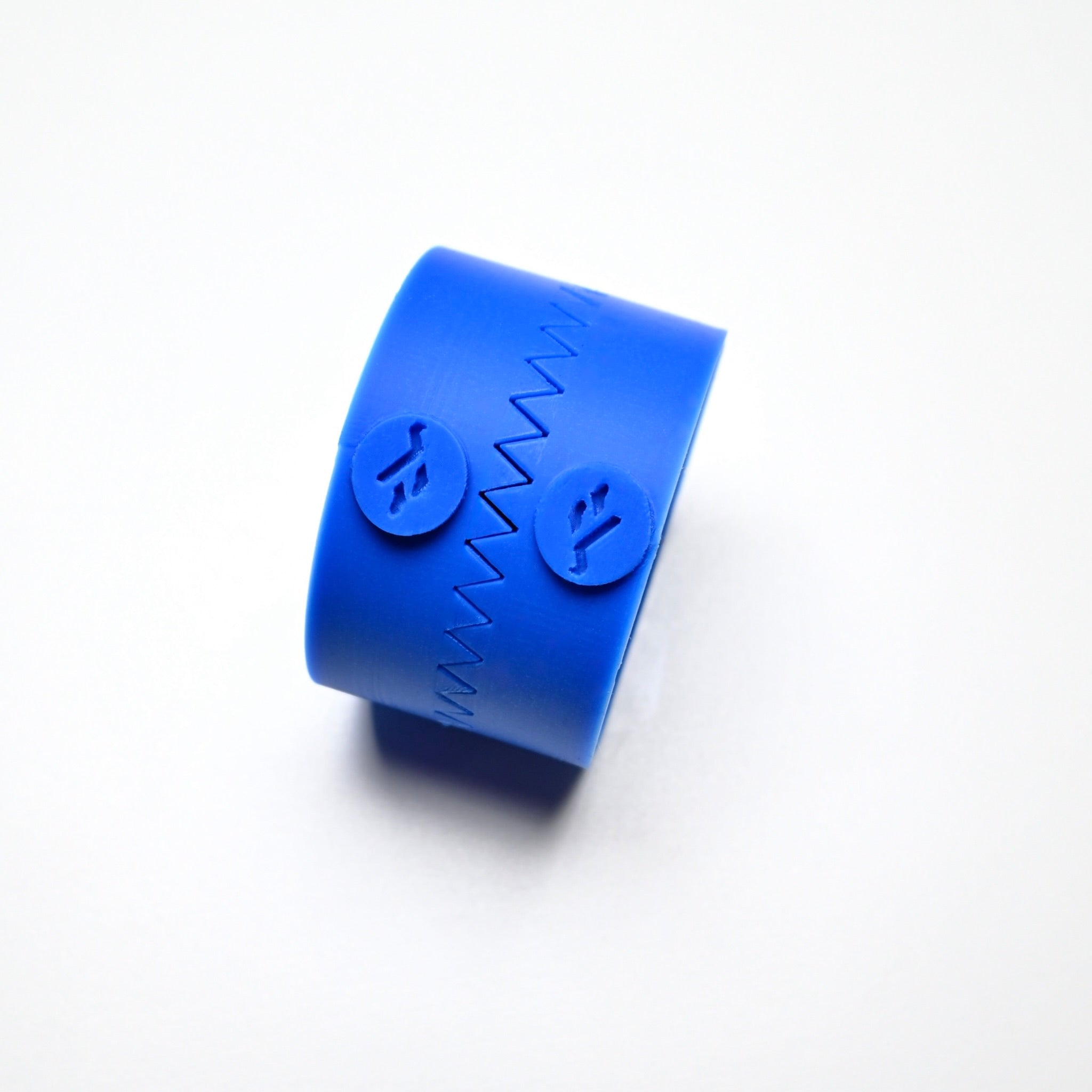 Blue silicone Fan Press pastry mold with a zigzag seam and circular logo details.