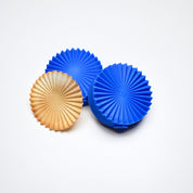 Blue silicone fan pastry molds next to a matching ribbed golden tuile cookie.
