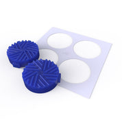Two blue silicone Helix presses with spiral-grooved circular shapes next to a white stencil.