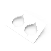 White plastic pastry stencil featuring two serrated birch leaf cutouts.
