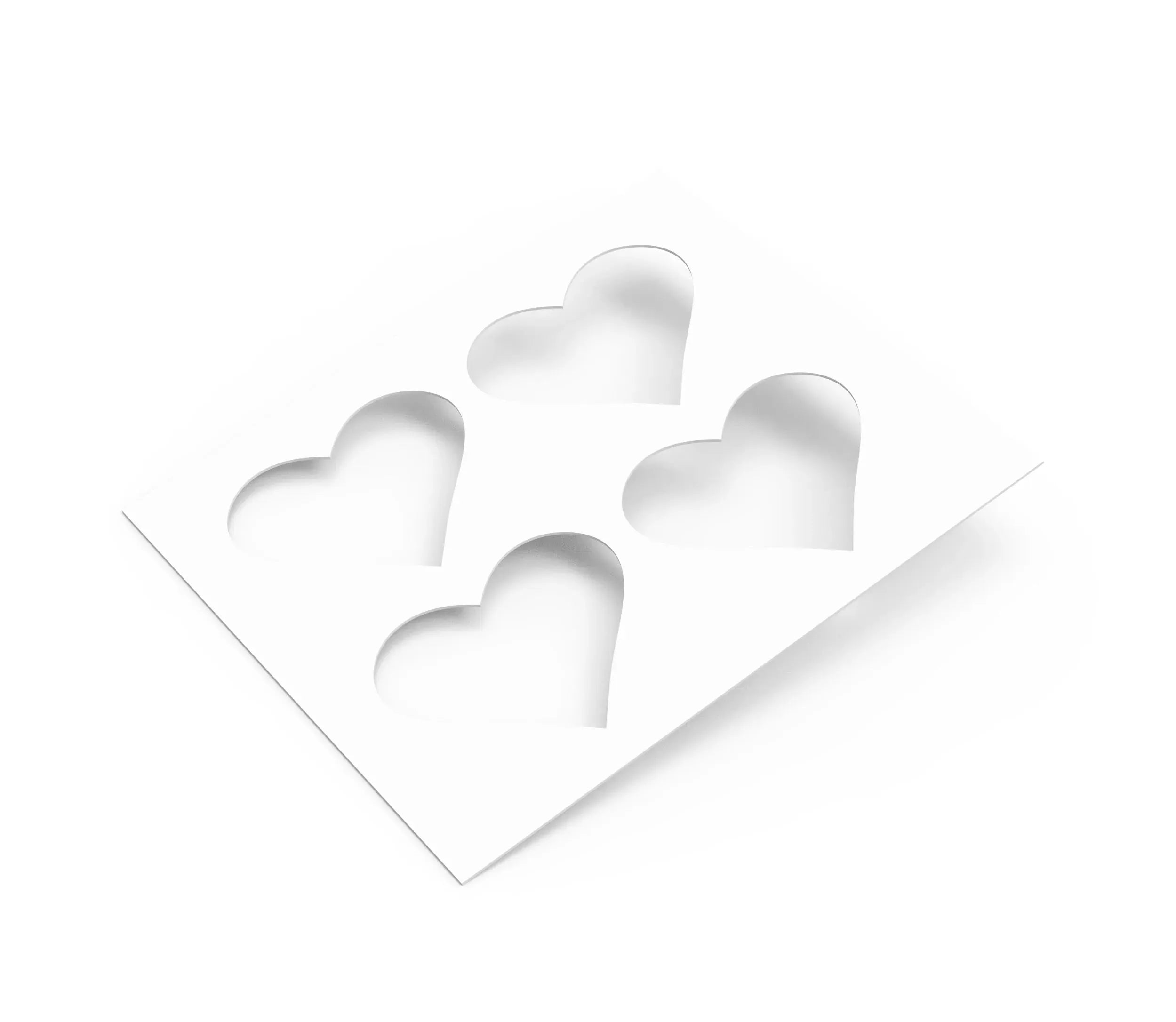 White plastic pastry stencil featuring four symmetrical heart-shaped cutouts.