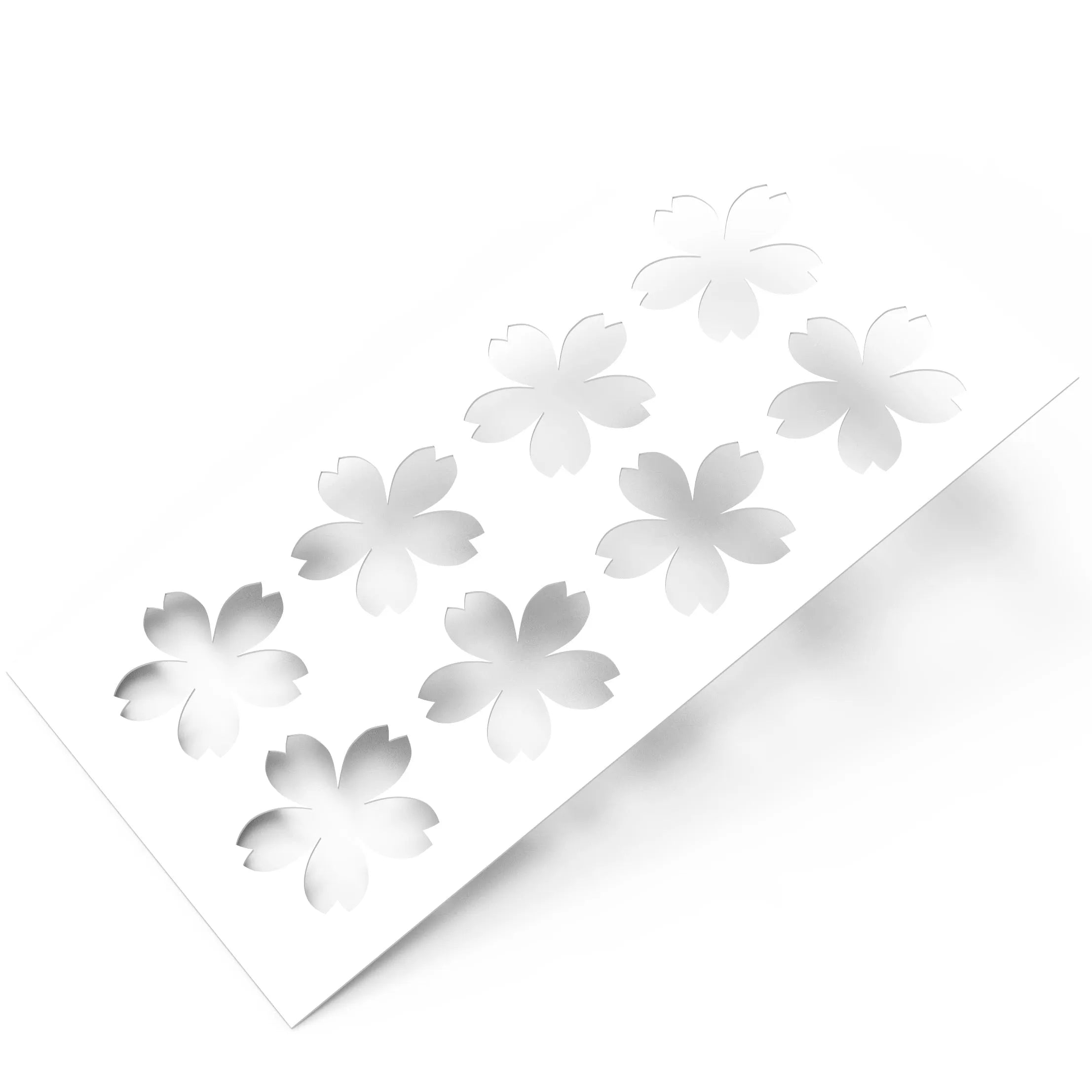 White plastic pastry stencil featuring eight cherry blossom sakura cutouts.