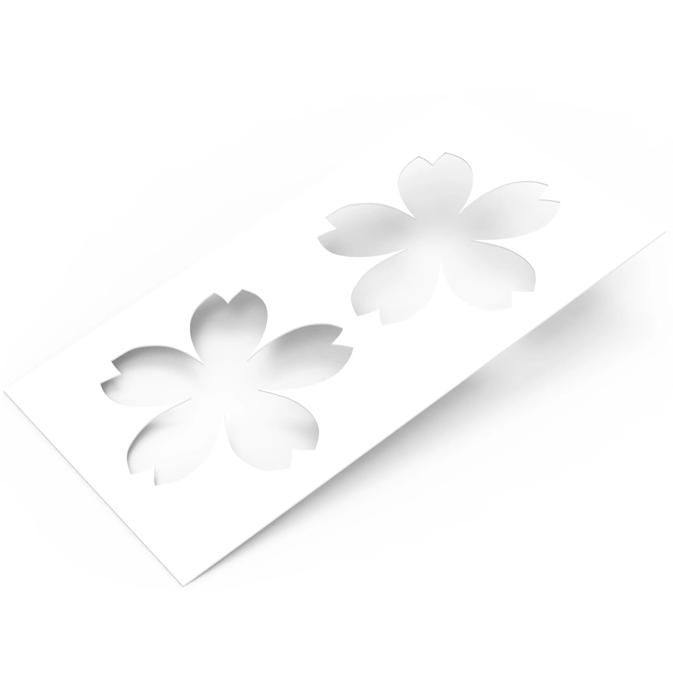 White plastic Sakura pastry stencil with two cherry blossom shaped cutouts.