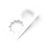 White plastic pastry stencil featuring two detailed, wavy-rayed sun shapes.