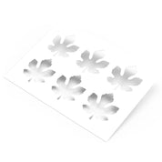 White plastic pastry stencil featuring six detailed fig leaf shaped cutouts.