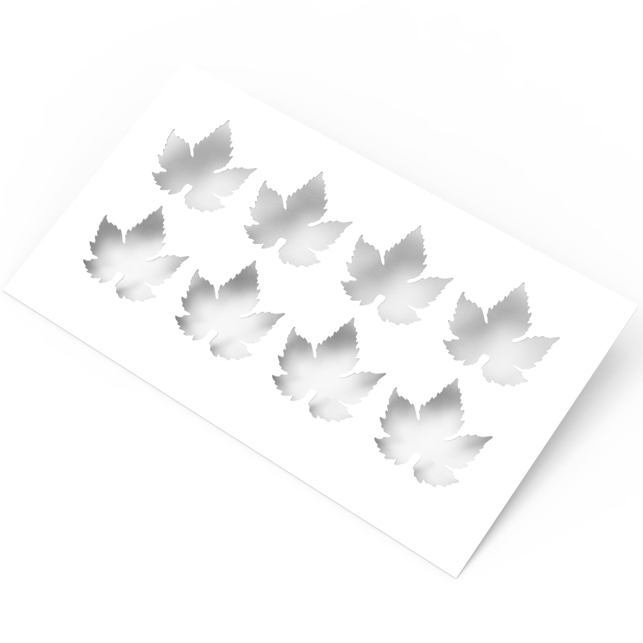 White culinary stencil sheet with eight detailed vine leaf shaped cutouts.
