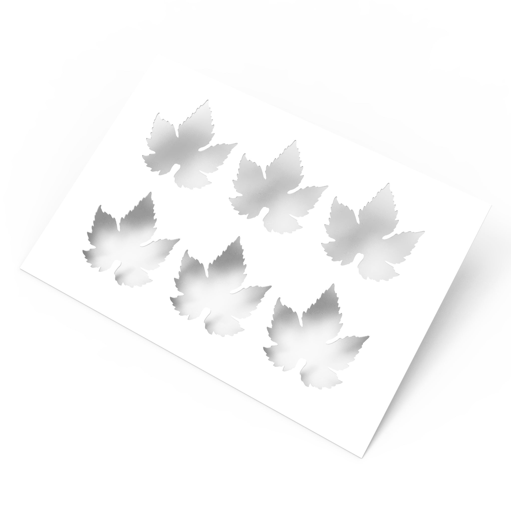 White culinary stencil sheet featuring six detailed vine leaf cutouts.