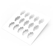 White plastic pastry stencil featuring fifteen detailed oak leaf cutouts.