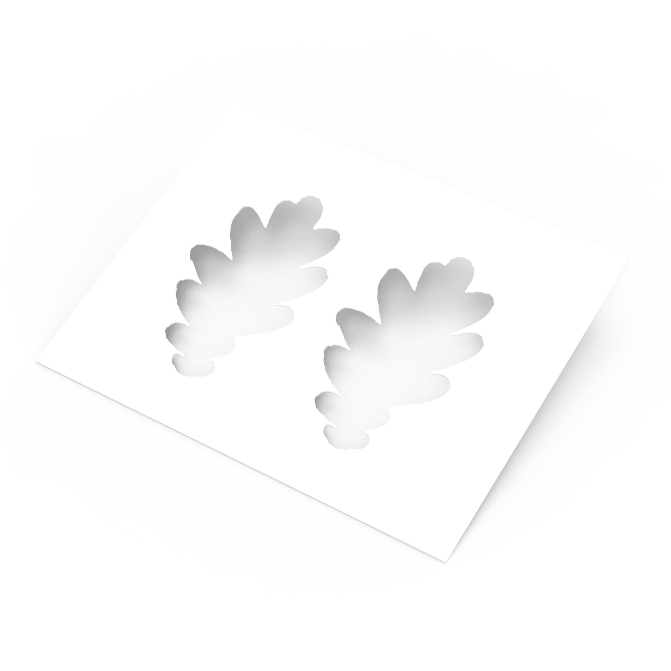 White plastic pastry stencil featuring two detailed oak leaf cutouts.