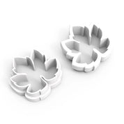Two white plastic vine leaf cookie cutters with detailed botanical shapes.