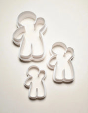 Three white plastic gingerbread man cookie cutters in small, medium, and large sizes.