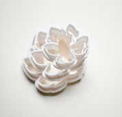 Stacked white plastic vine leaf cookie cutters showing detailed botanical shapes.
