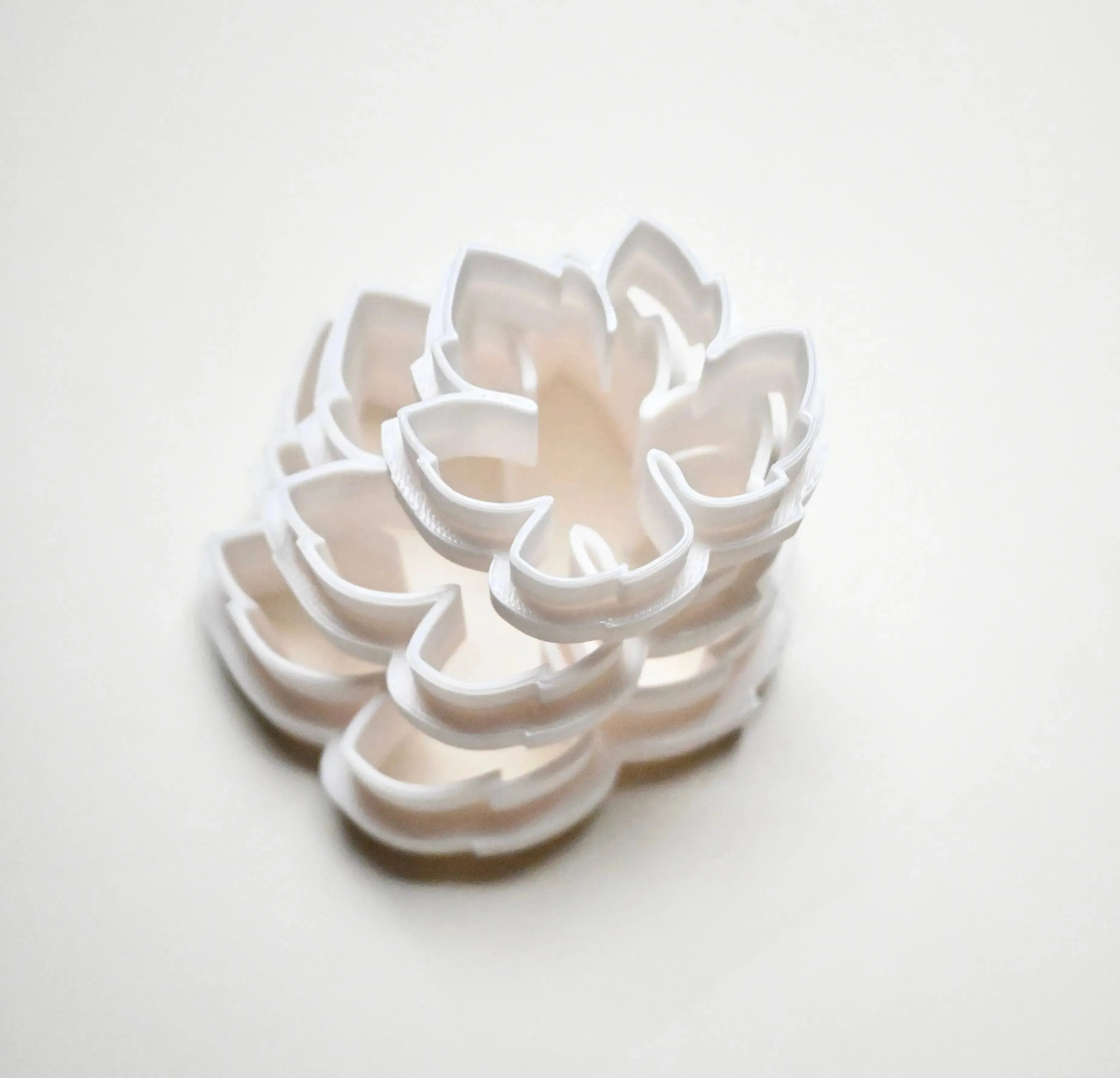 Stacked white plastic vine leaf cookie cutters showing detailed botanical shapes.