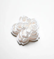 Stacked white plastic sakura flower cookie cutters in various sizes.