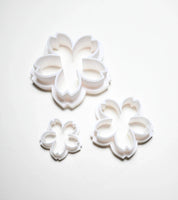 Three white plastic sakura cherry blossom cookie cutters in small, medium, and large sizes.