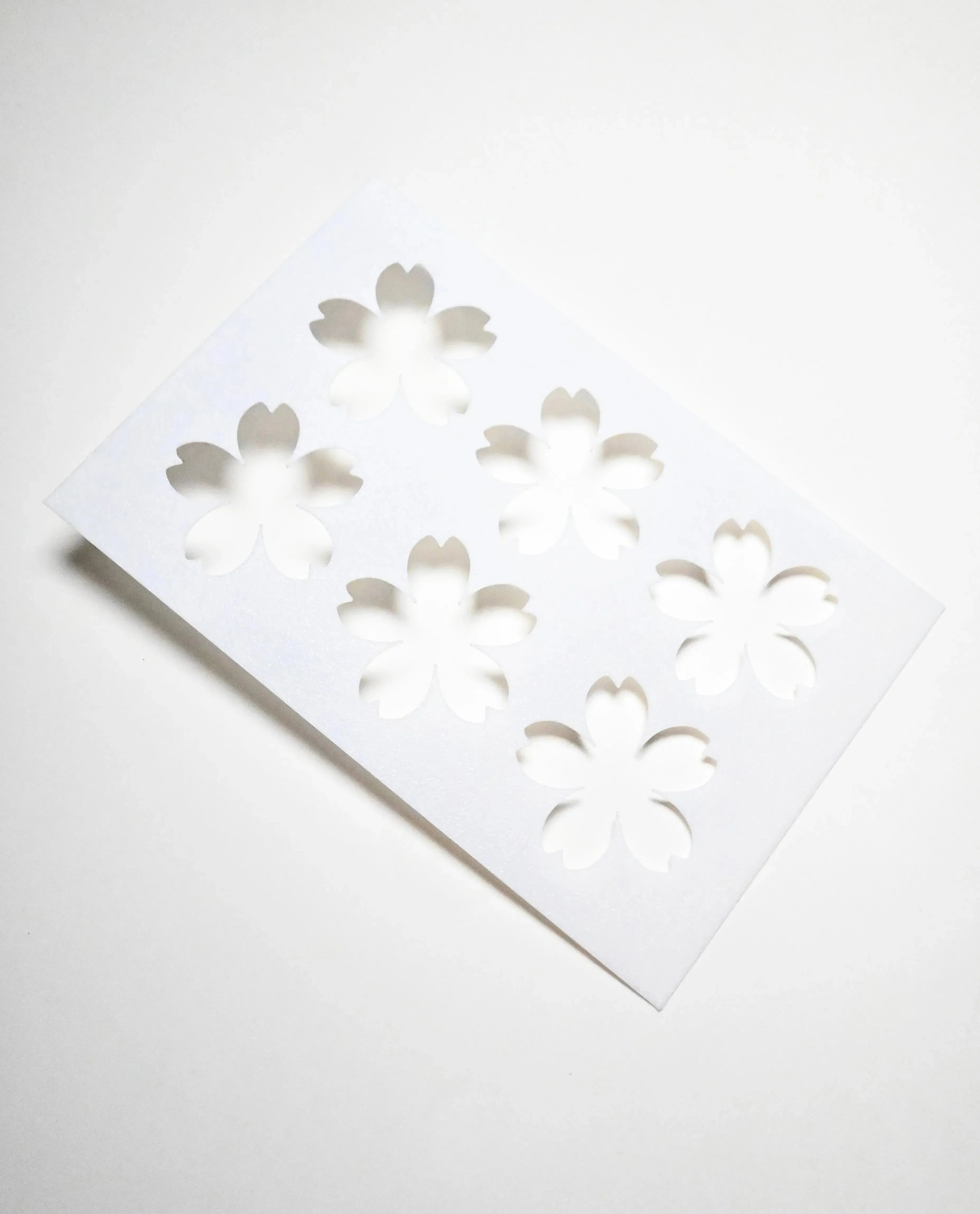 White Sakura pastry stencil with six cherry blossom cutouts.