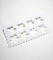 White plastic Sakura pastry stencil with eight cherry blossom shaped cutouts.