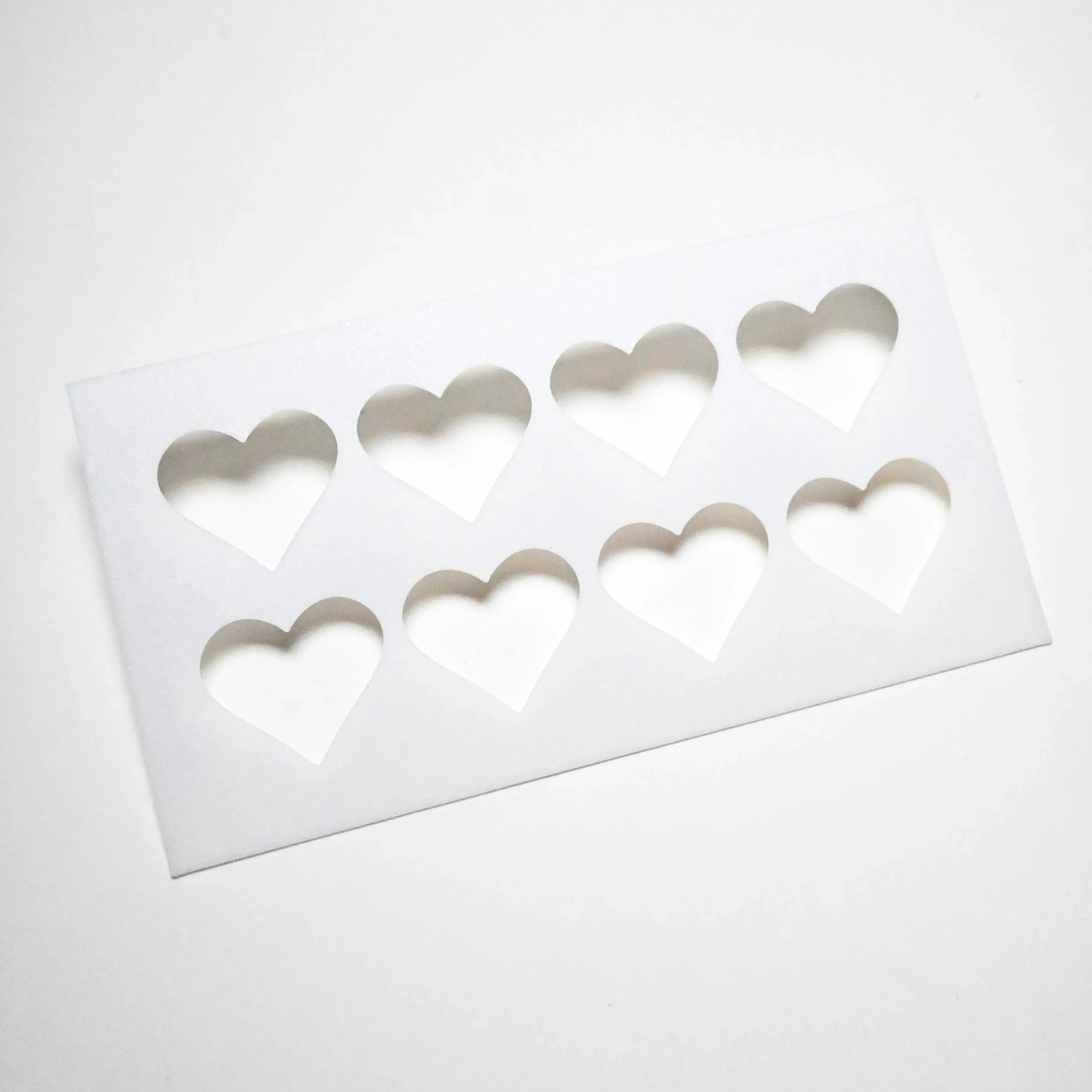 White rectangular pastry stencil featuring eight heart-shaped cutouts in two rows.