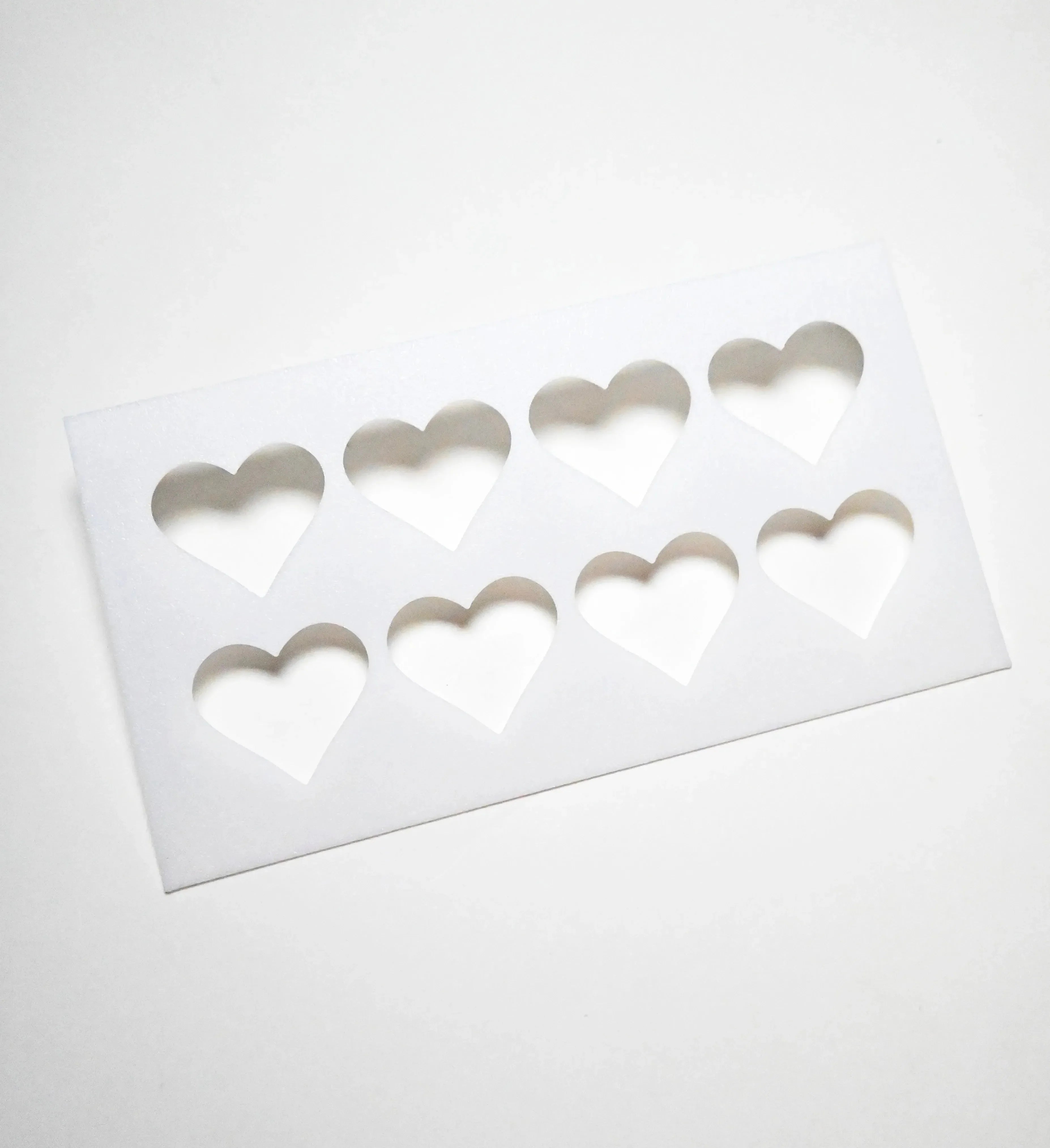 White rectangular pastry stencil featuring eight heart-shaped cutouts in two rows.