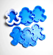 Blue and white silicone gingerbread boy molds with detailed smiling faces.