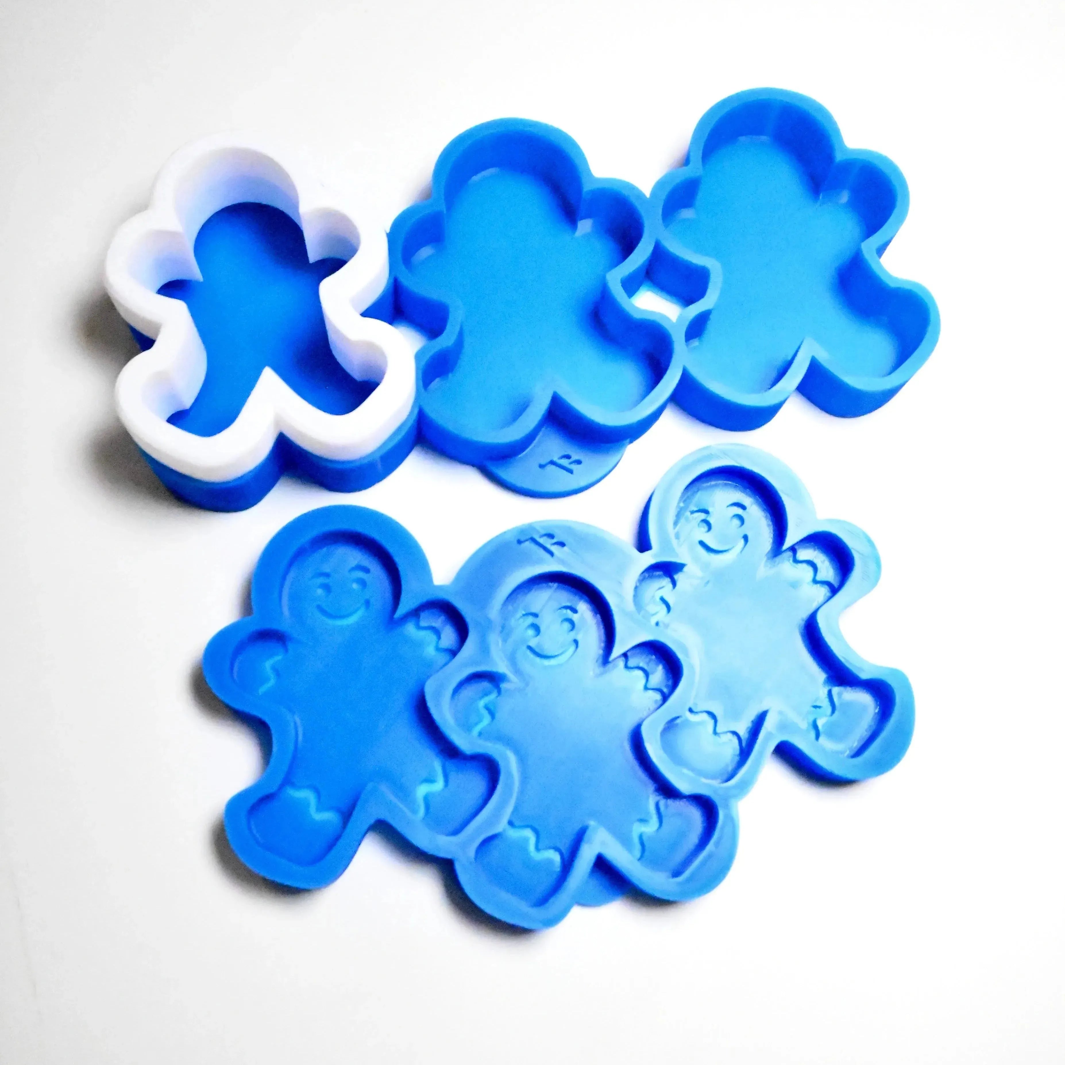 Blue and white silicone gingerbread boy molds with detailed smiling faces.