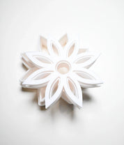 White plastic star anise flower cookie cutter with a detailed eight-petal geometric design.