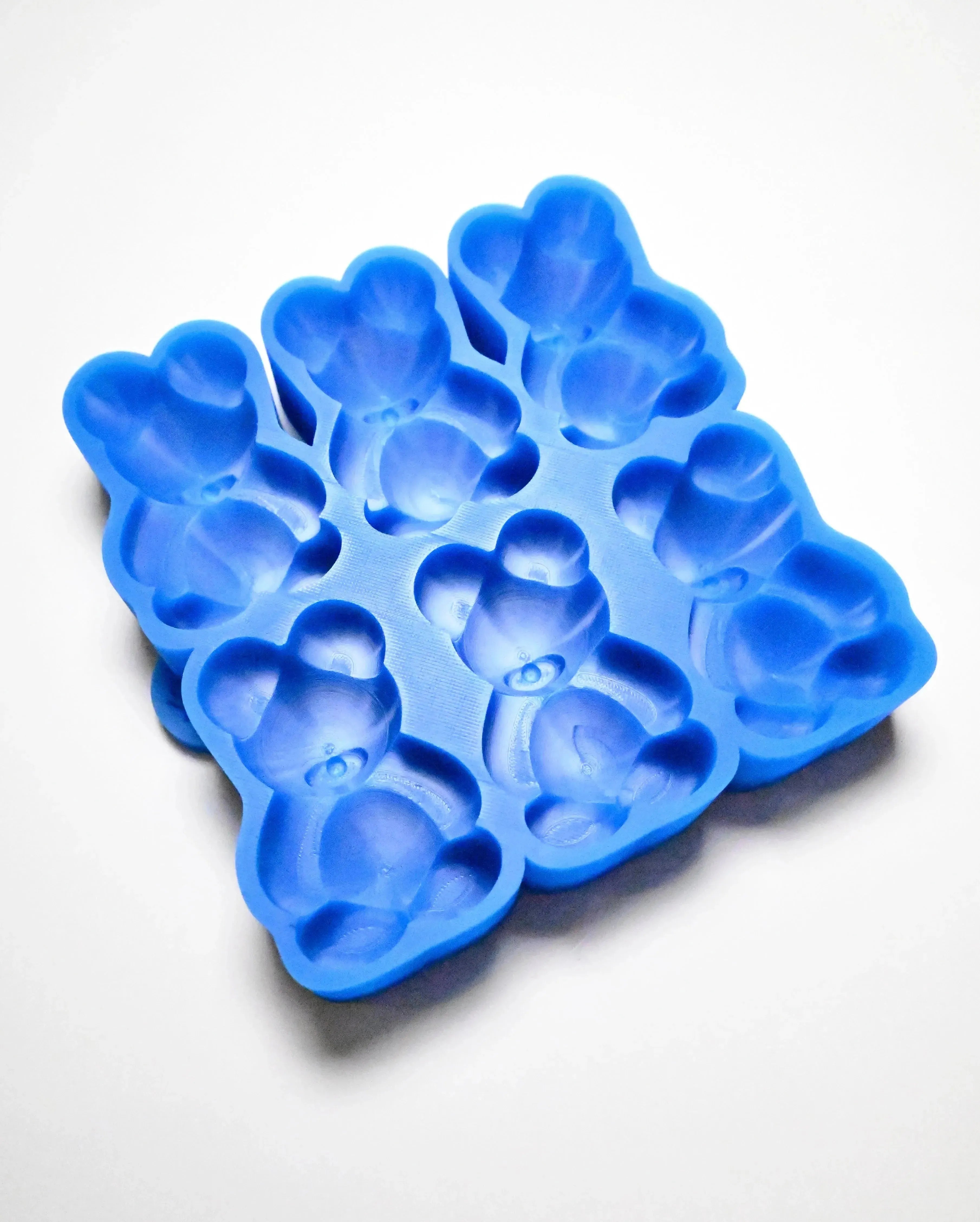 Blue silicone mold with six detailed bear-shaped cavities for baking and chocolate making.