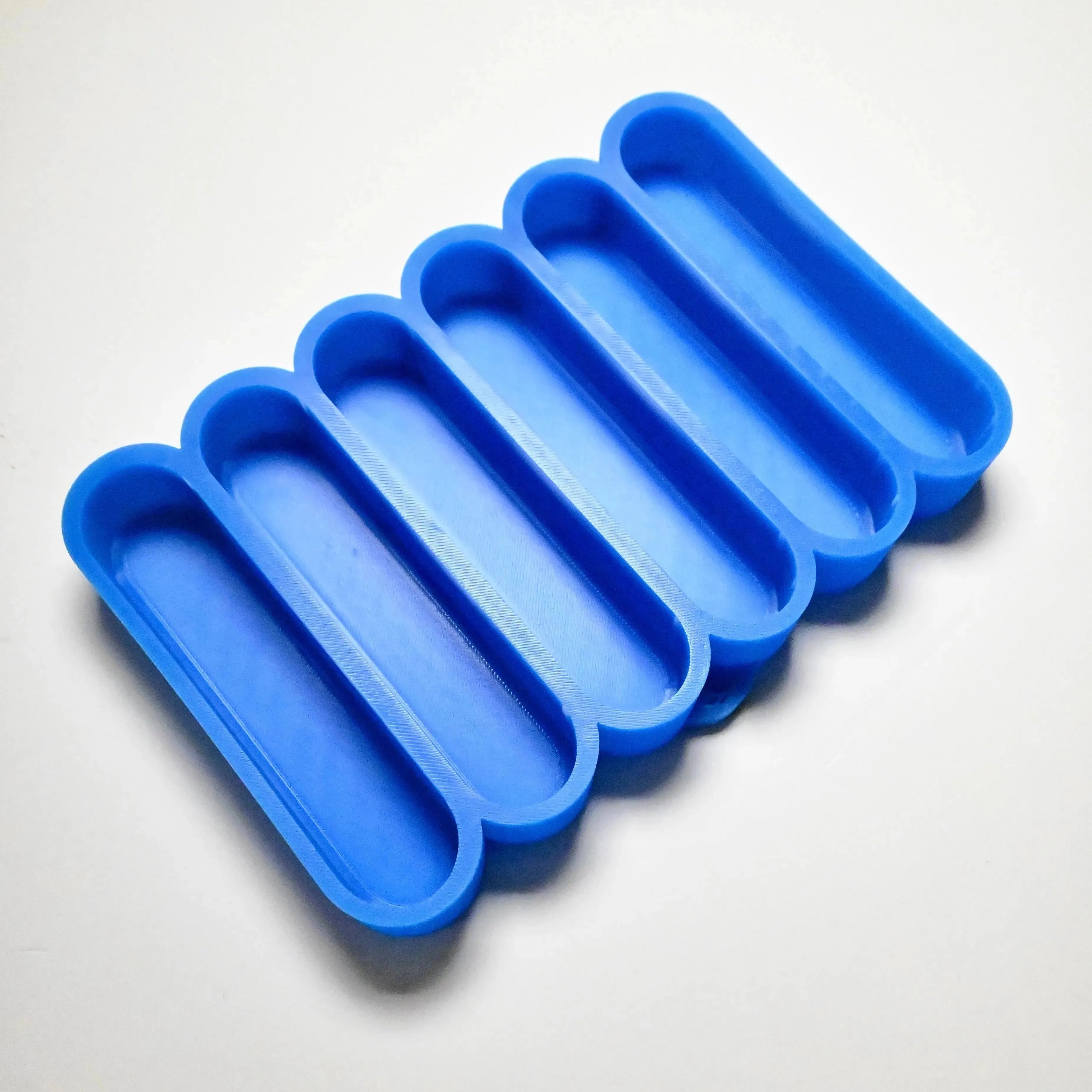 Blue silicone mold with six long, rounded finger-shaped cavities for pastry making.