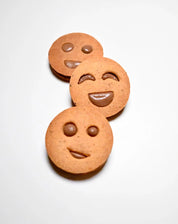 Three round smiley face cookies with chocolate filling, showing different happy expressions.
