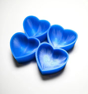 Four blue heart-shaped silicone pastry molds arranged on a white surface.
