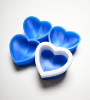 Blue silicone heart-shaped pastry molds with a white plastic support rim.