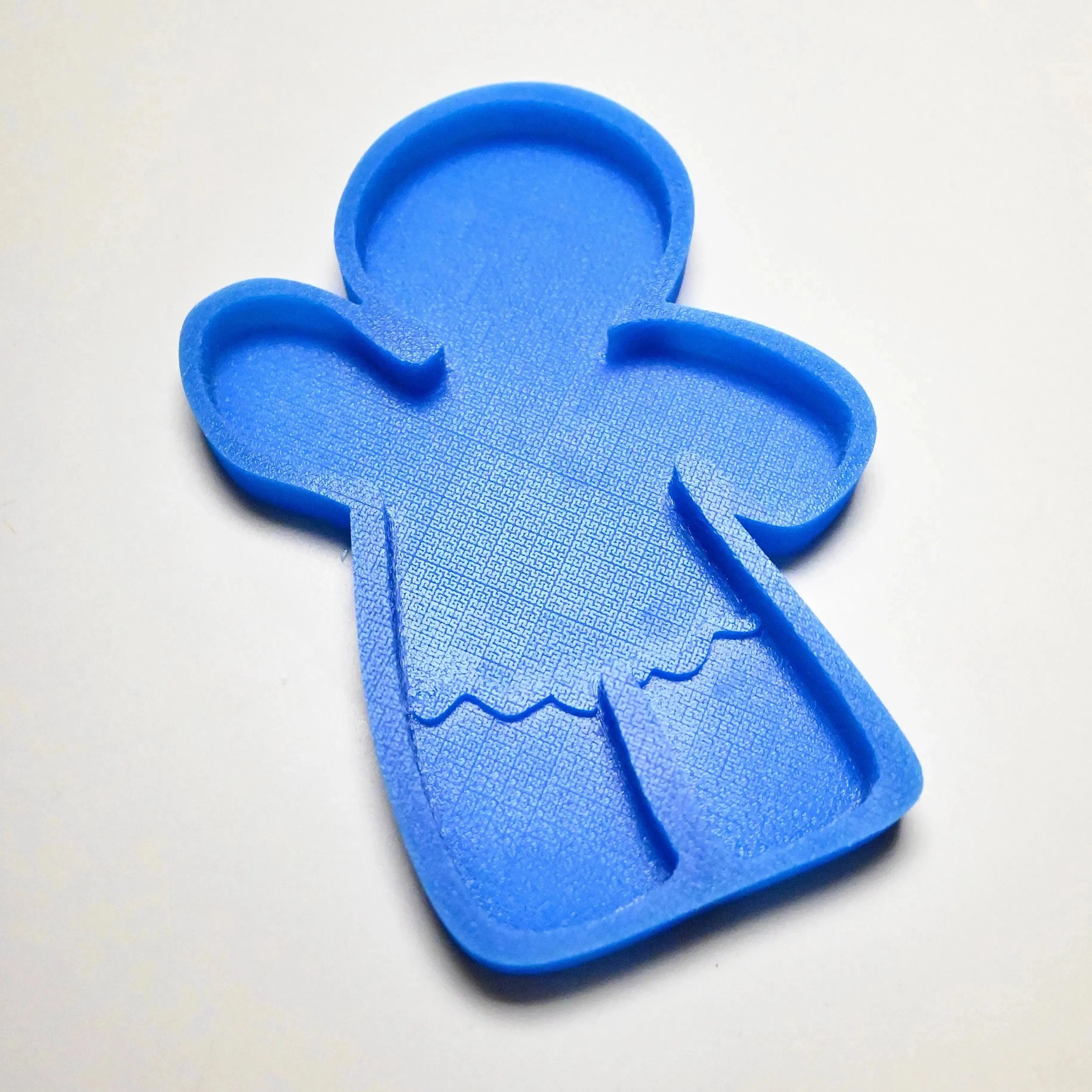 Blue silicone gingerbread man mold with textured details on a white background.
