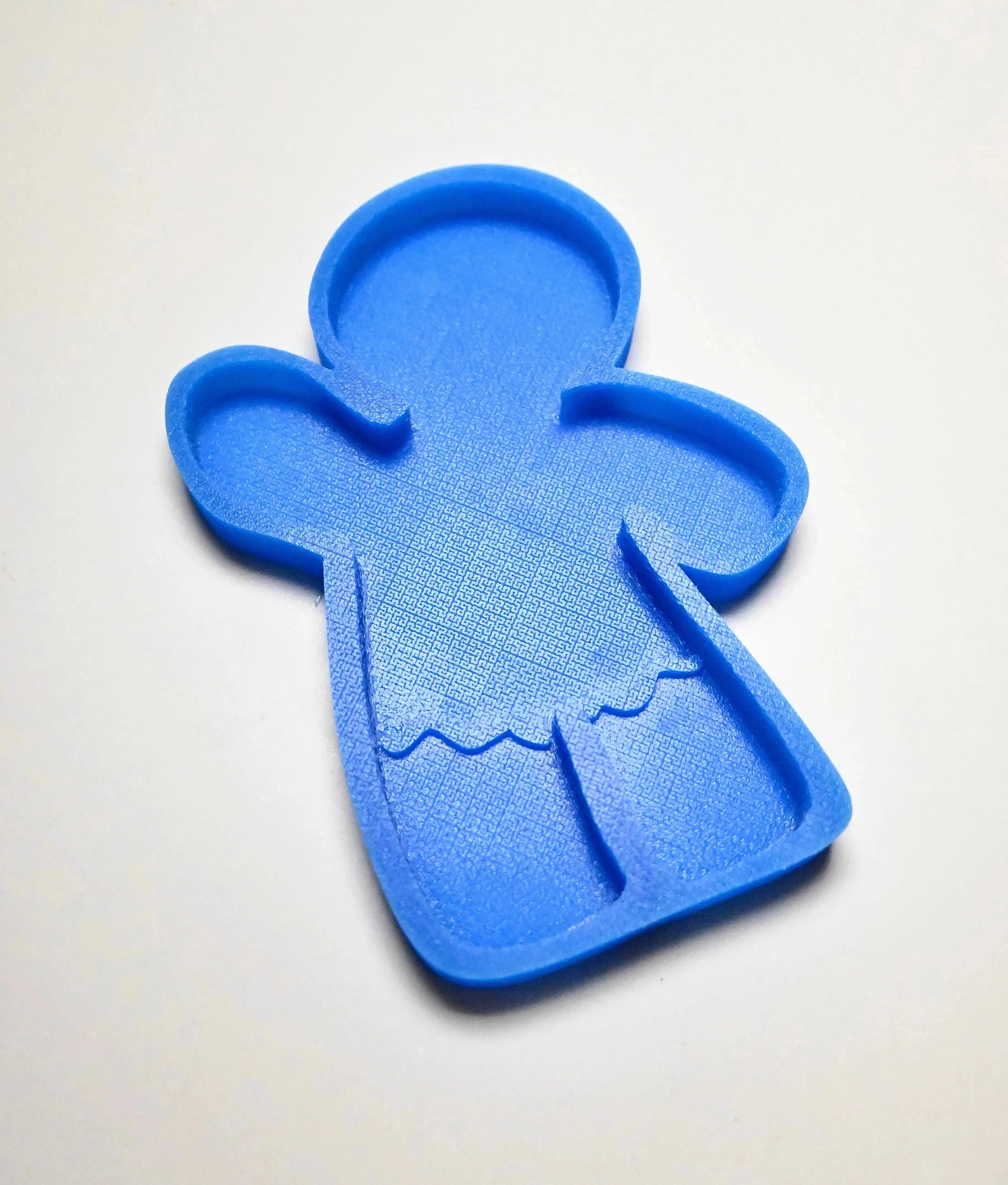 Blue silicone gingerbread man mold with textured details on a white background.