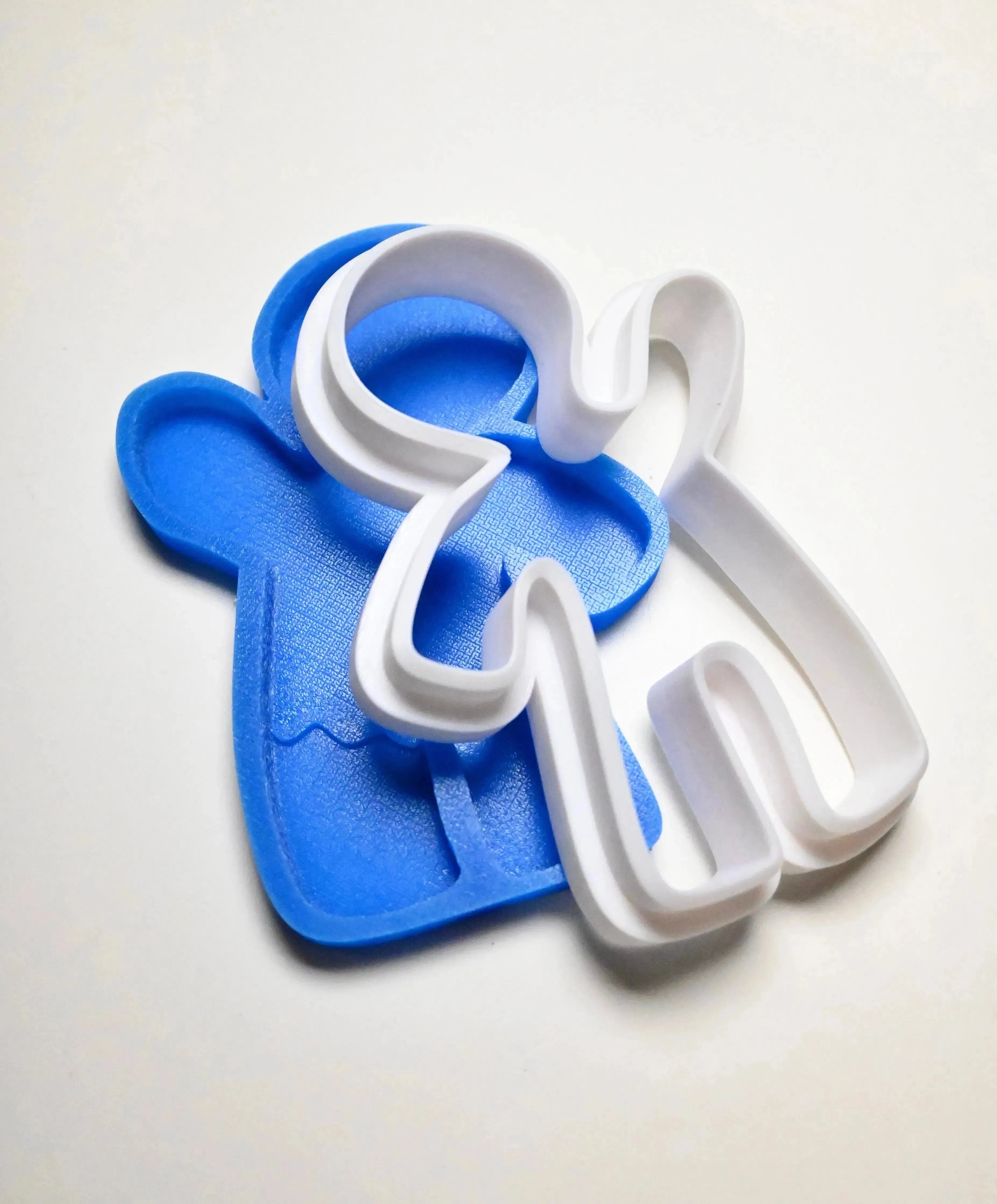 Blue gingerbread man silicone mold with a white plastic outline cutter.
