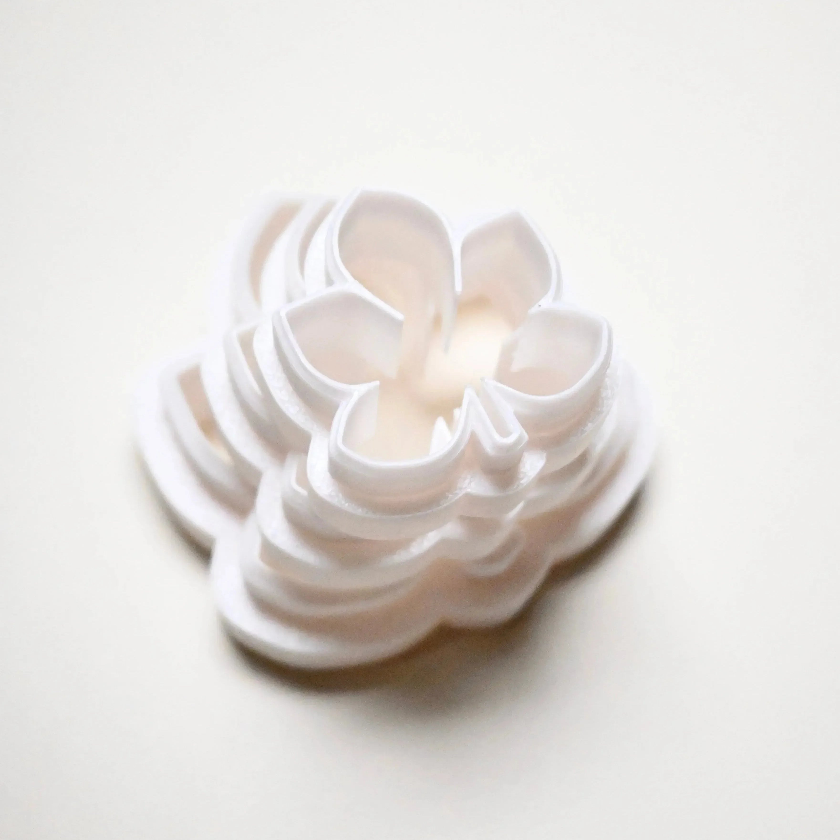 Stacked white plastic horse chestnut leaf cookie cutters in graduated sizes.