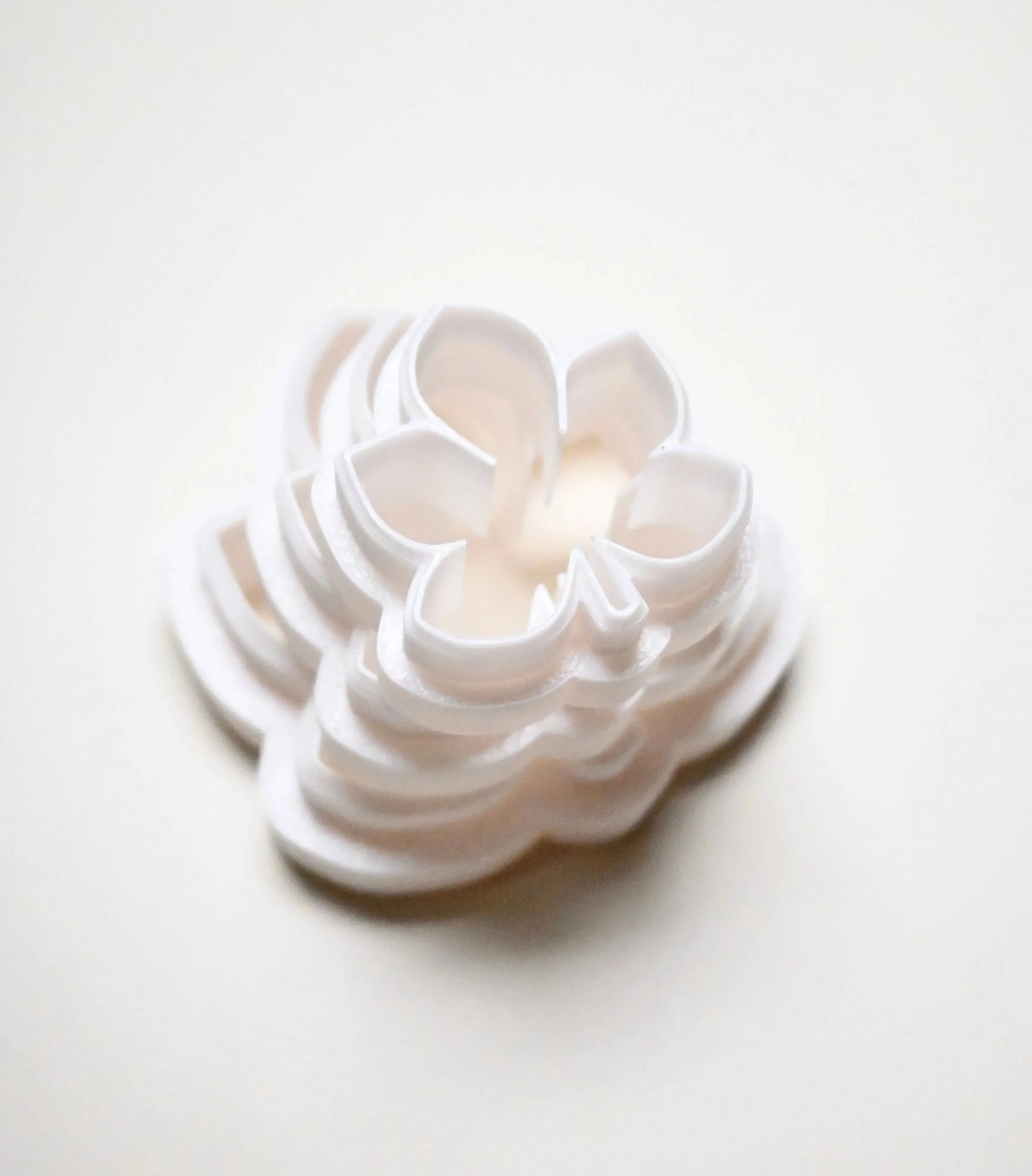 Stacked white plastic horse chestnut leaf cookie cutters in graduated sizes.