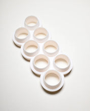 White multi-cookie cutter with eight circular molds in a staggered layout.