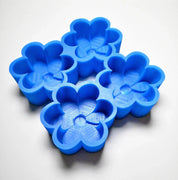 Blue silicone daisy mold with four detailed flower-shaped cavities.