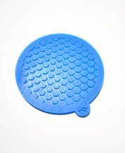 Round blue silicone tuile mat with a hexagonal honeycomb mold pattern.