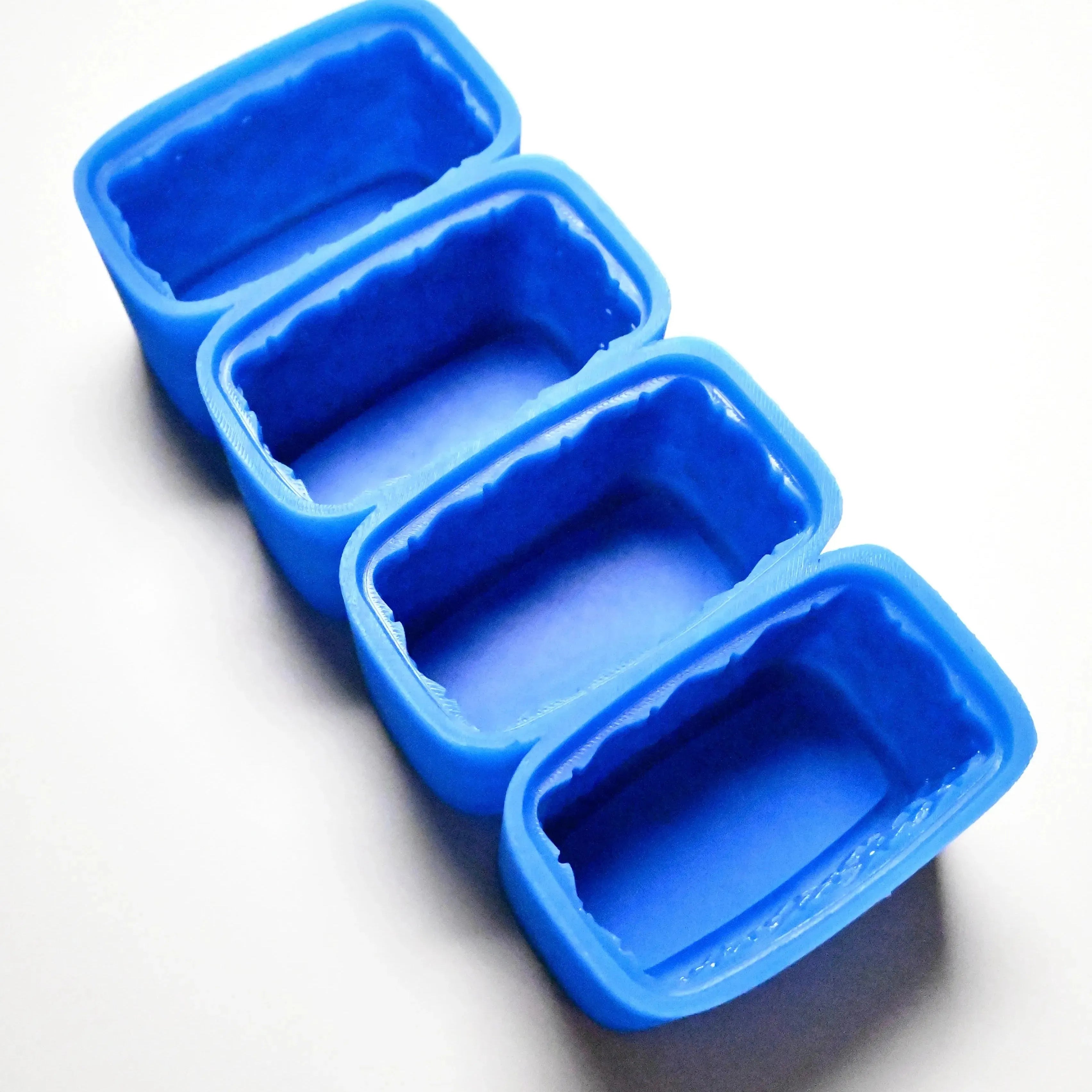 Four rectangular blue silicone basket molds lined up on a white surface.