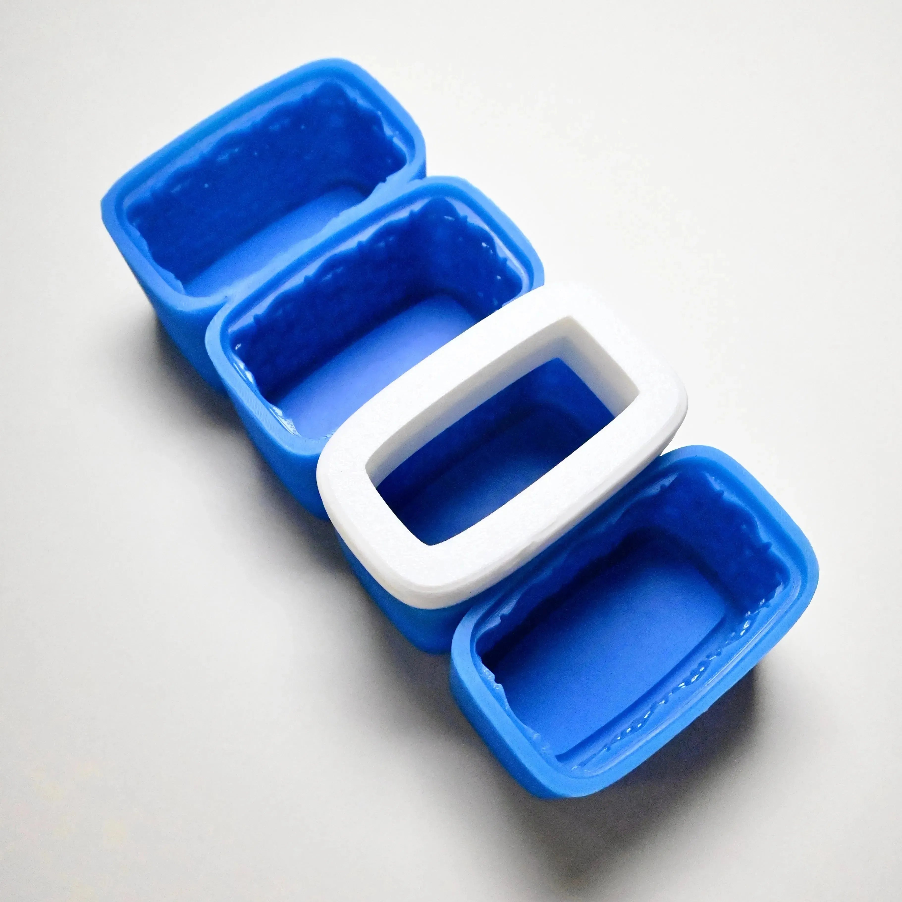 Blue silicone basket mold with rectangular cavities and a white plastic support ring.