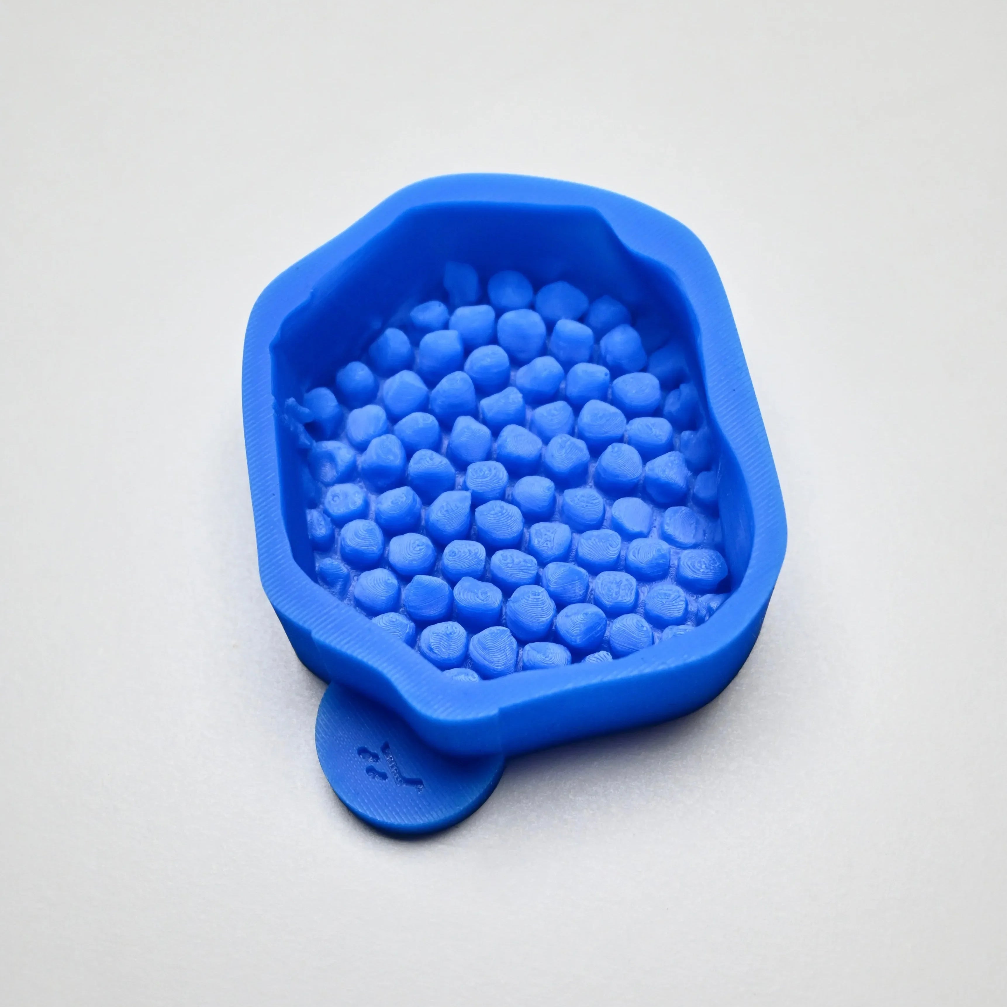 Blue silicone honeycomb fragment mold with irregular natural cell shapes.