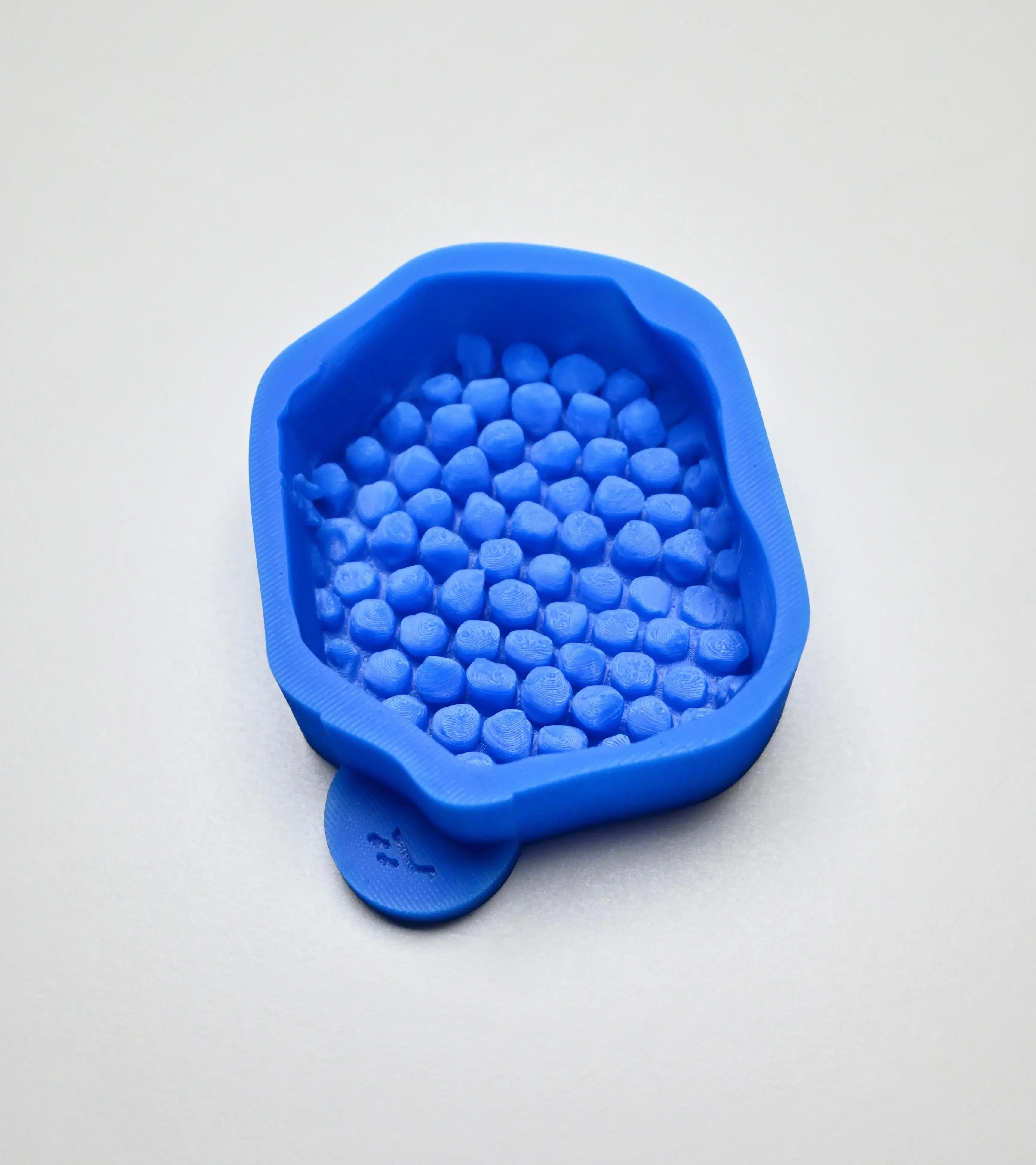 Blue silicone honeycomb fragment mold with irregular natural cell shapes.