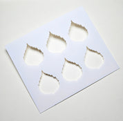 White plastic birch leaf stencil with six serrated leaf-shaped cutouts for pastry decoration.