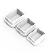 Three white plastic fluted rectangle cookie cutters in descending sizes.