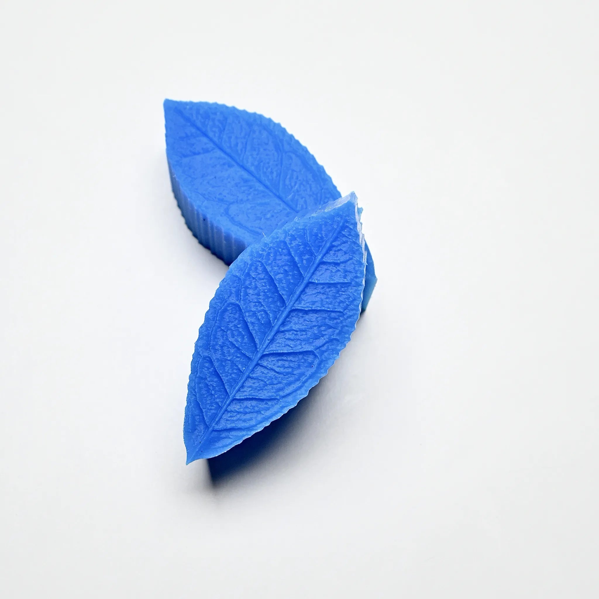 Blue silicone tea leaf press molds showing detailed leaf vein textures on a white background.