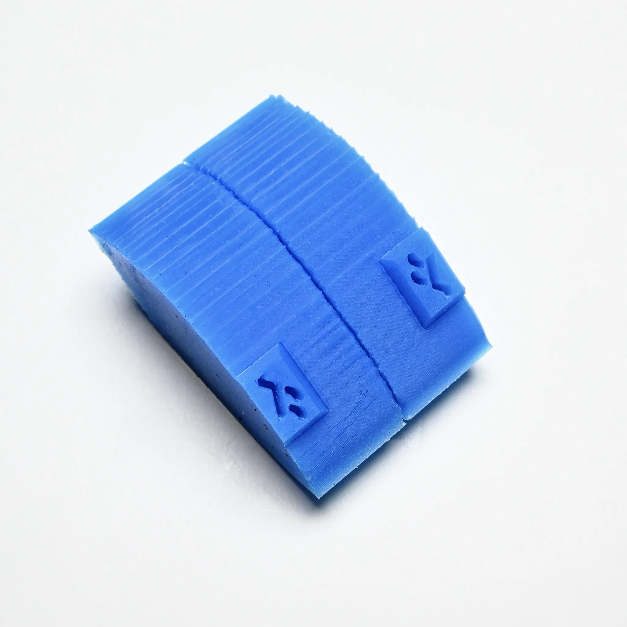 Blue silicone tea leaf press mold with a curved, textured rectangular shape.