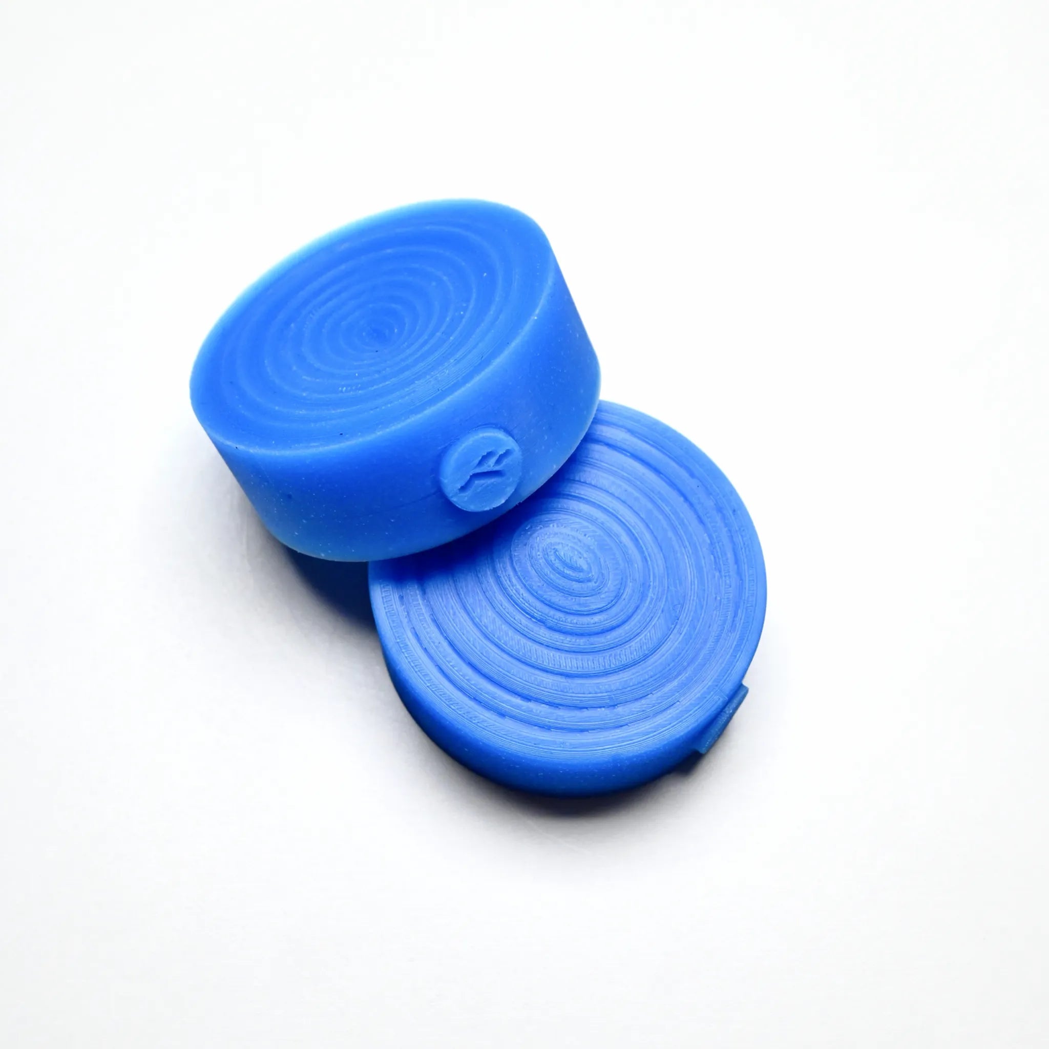 Two blue round silicone pastry molds with concentric textured spiral designs.
