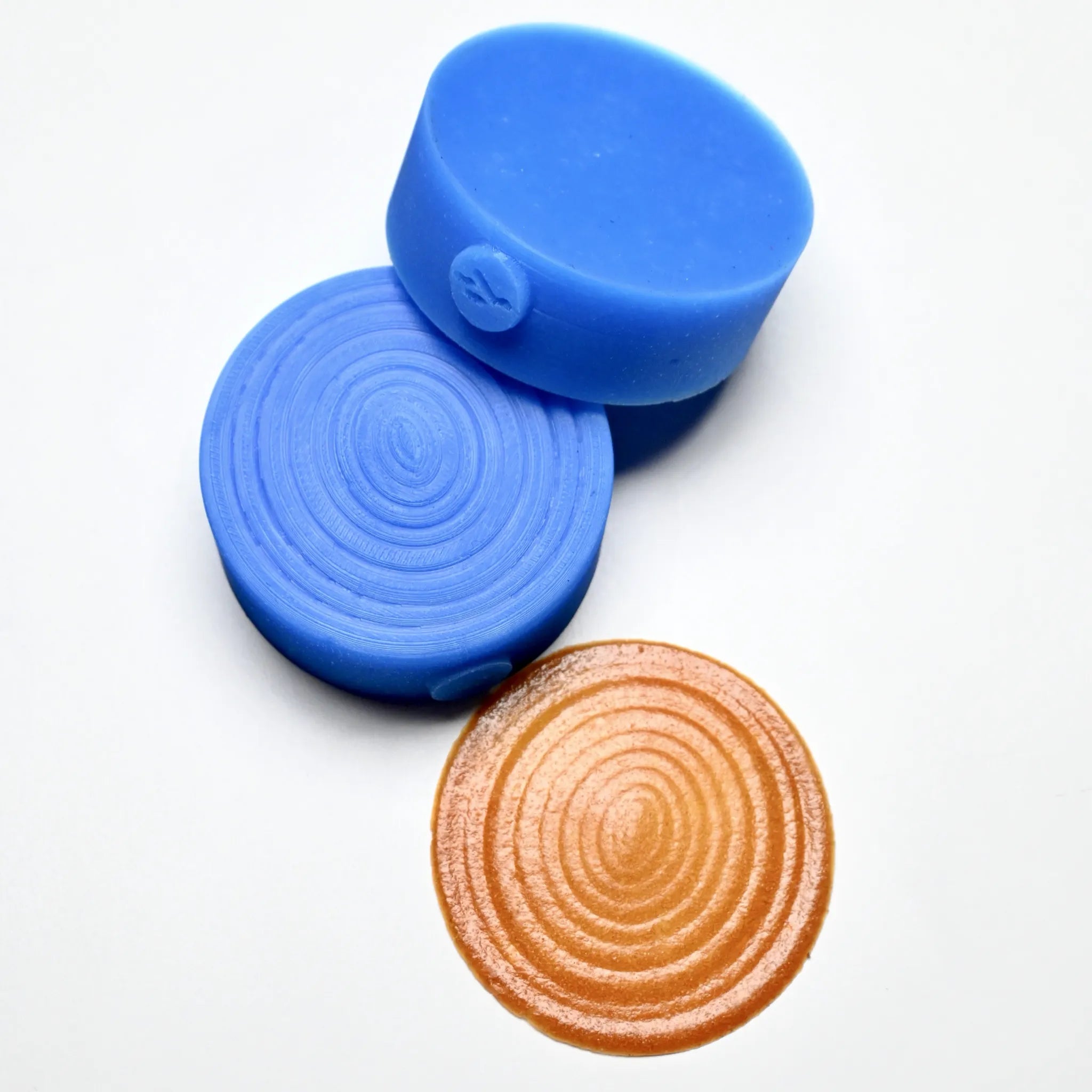 Blue round silicone Resonance pastry presses with concentric circle textured molds.