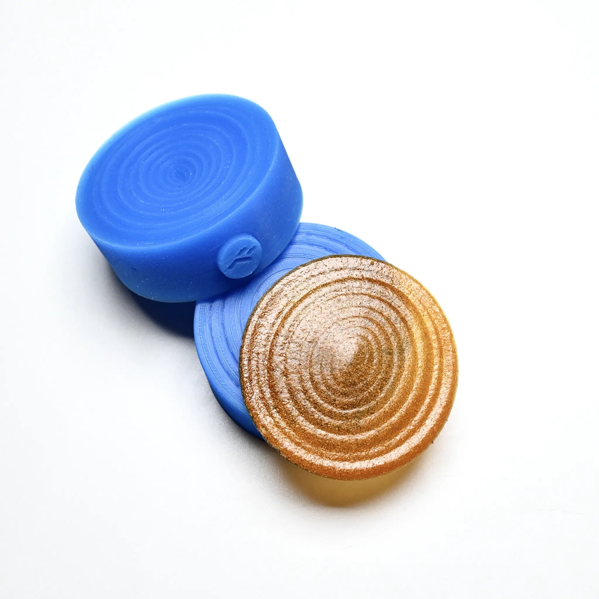 Blue silicone Resonance pastry press with a textured, circular spiral design mold.